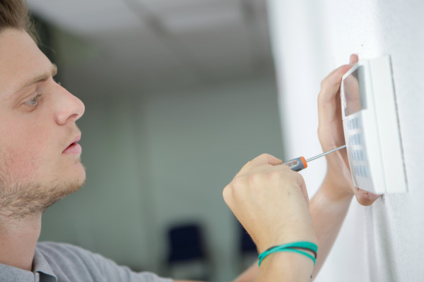 Un technicien pose un clavier d'alarme intrusion - détection intrusion - télésurveillance